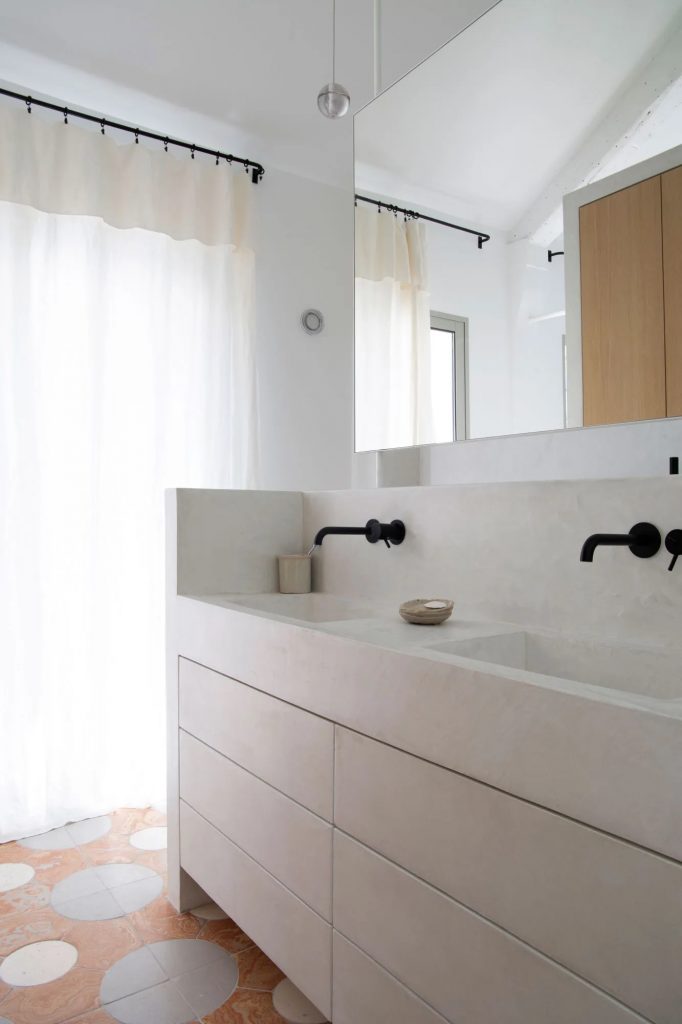 Biała łazienka z czarną armaturą i terrakotą na podłodze